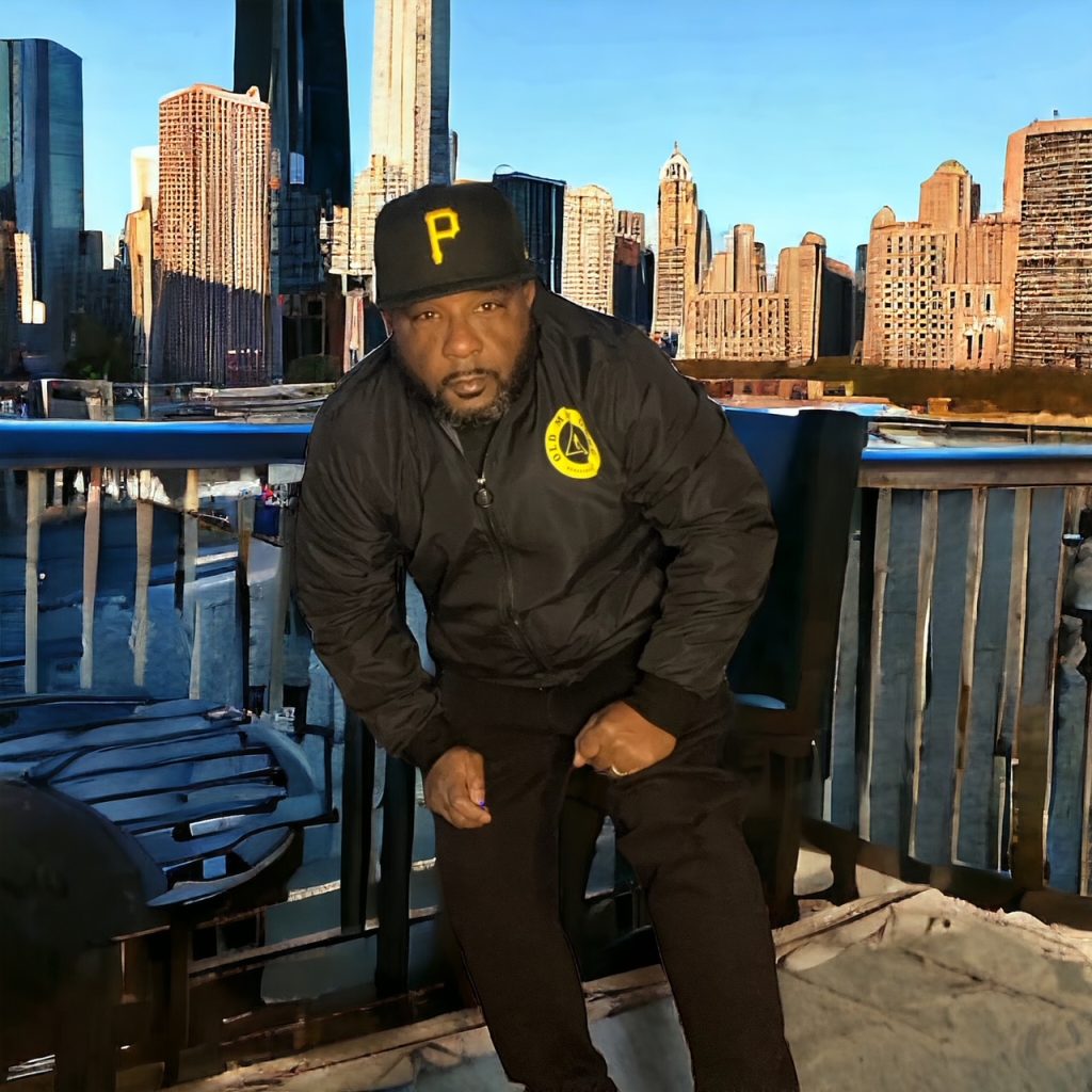 A man sitting on top of a bench in front of the city.